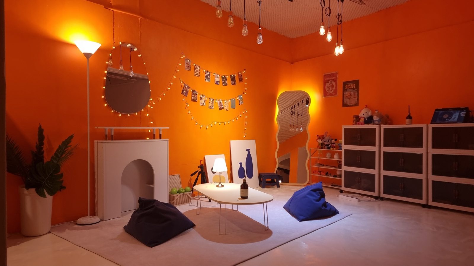 The orange room &mdash; bean bags around a low table, string lights and a wall of photos.